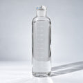 Nivosa Clear Bottle, 500 ml glass water bottle with white hourly time markers, on a light studio background